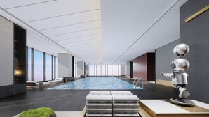 A modern indoor swimming pool with a clear ceiling, a robotic figure, and a stack of towels. - Crowne Plaza Suzhou East Taihu by IHG (Suzhou)