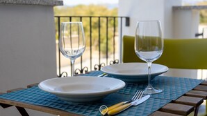 A table with two plates and two glasses, a fork, and a knife on a blue placemat. - Orange Apartment 4 - Wonderful Vacation (Tortolì)