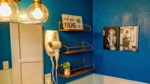 A bathroom with a blue wall, a white door, a hairdryer, and a sign that says "wash your PALMS". - Retro Retreat - A Desert Oasis (Twentynine Palms)