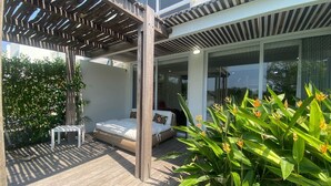 A modern outdoor patio area with a wooden pergola, a bed, and lush greenery. - Hermosa casa en Cartagena , en el Club Karibana (Cartagena)