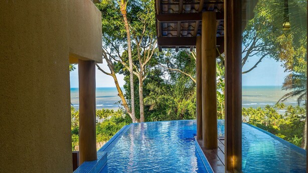 A clear view of a swimming pool with a view of the ocean and surrounding greenery. - Individual "Lux" villa with private pool (Arraial D'Ajuda)