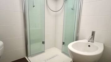 Een douche, een bidet, handdoeken