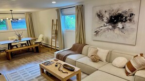 Ein modernes Wohnzimmer mit einer Couch, einem Couchtisch und einem Gemälde an der Wand.