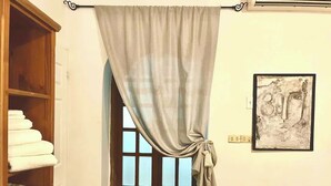 A room with a wooden wardrobe, a door with a curtain, and a framed artwork on the wall. - Room #3 two blocks from the Malecon (La Paz)