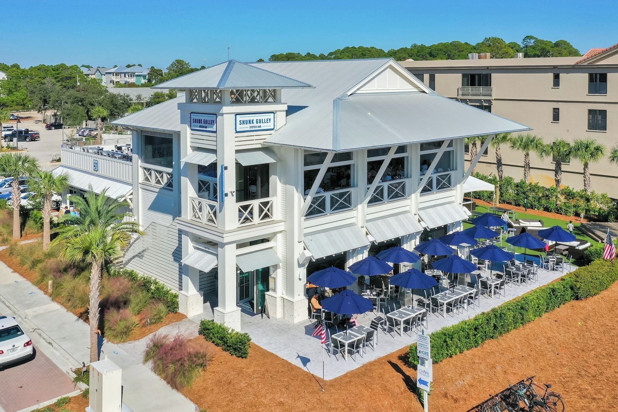 A coastal building with a balcony and outdoor seating area.