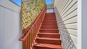 A staircase with a wooden handrail and a lattice fence on one side.