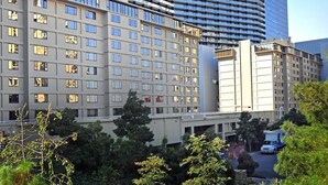 Un hotel con fachada moderna, varios pisos y un cartel llamativo.