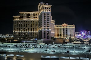 Een groot hotelcomplex met meerdere gebouwen, een parkeerplaats met veel auto's en een opvallend casino-bord in de achtergrond.