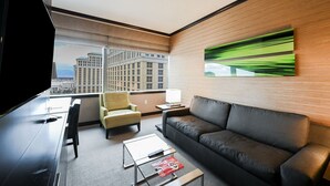 A modern hotel room with a large window offering a city view, a sofa, a chair, a coffee table, and a flat-screen TV. - Vdara Studio • City View • Free Valet • Pool • L20 (Las Vegas)