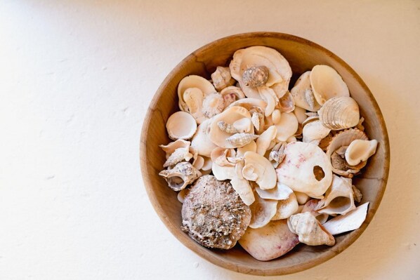 A wooden bowl filled with various seashells.