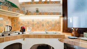Una cocina con estufa, lavaplatos y salpicadero de azulejos.