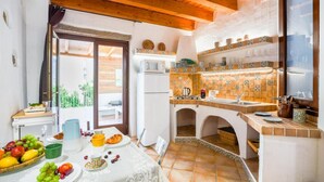 Cocina con techo de madera, salpicadero de azulejos y comedor con mesa lista para el desayuno.