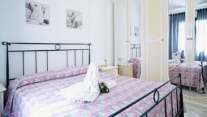 A hotel room with a bed, a nightstand, a mirror, and a wardrobe. - San Teodoro, Martino House (San Teodoro)