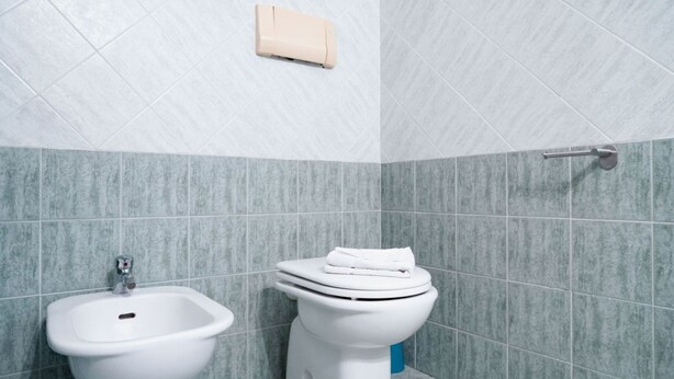 A bathroom with a bidet, a toilet, and a towel rack. - San Teodoro, Martino House (San Teodoro)