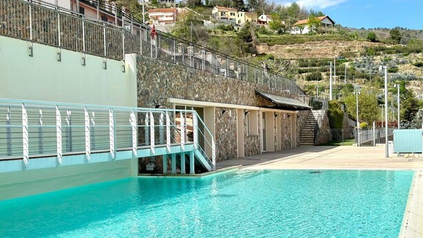 Ein Schwimmbad mit Steinmauer und Metallgeländer.