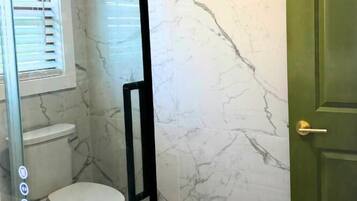 Ein Badezimmer mit Toilette, Waschbecken und einer Tür.