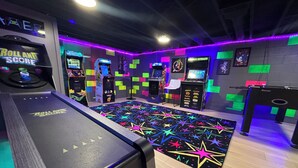 A gaming arcade with various arcade machines, a neon-lit floor, and a 'Roll and Score' game.