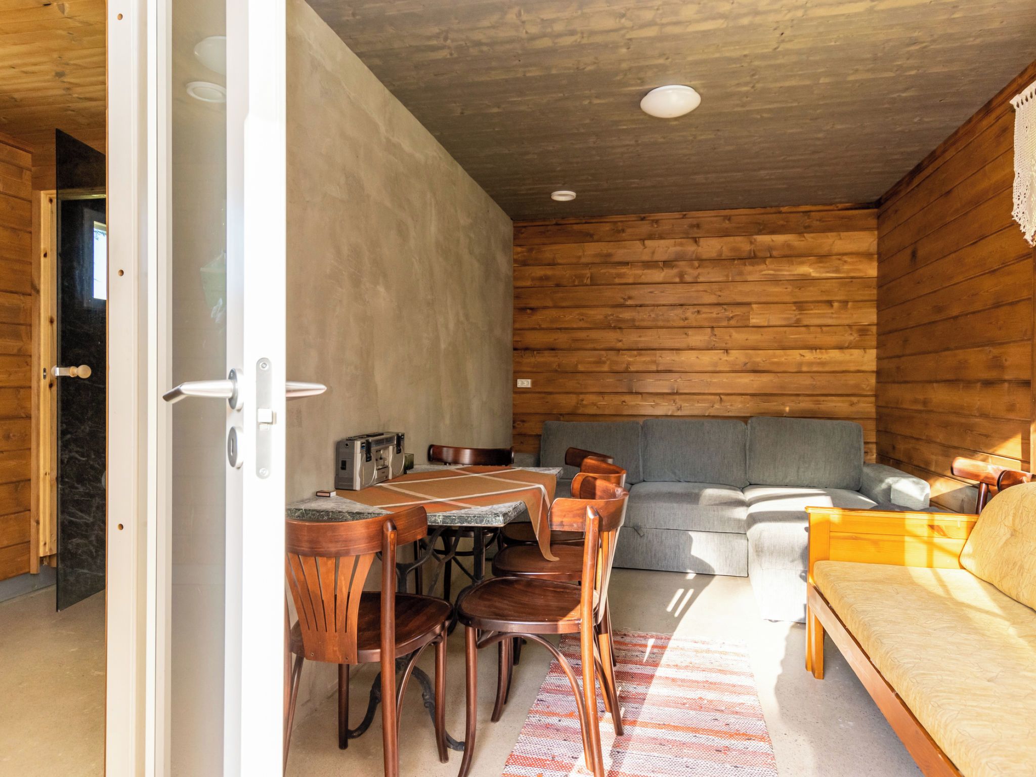 Een gezellig interieur met een eethoek, bank en een bed.