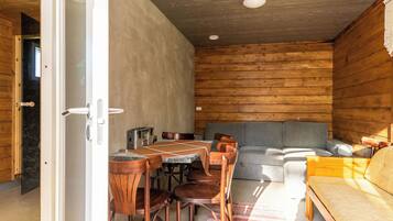 Een gezellig interieur met een eethoek, bank en een bed.
