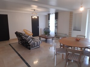 Un soggiorno moderno con divano, tavolo da pranzo, sedie e lampadario.