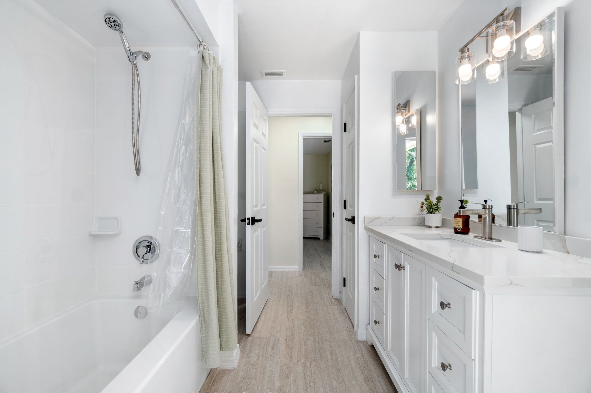 Un baño moderno con bañera, ducha y tocador con espejo.