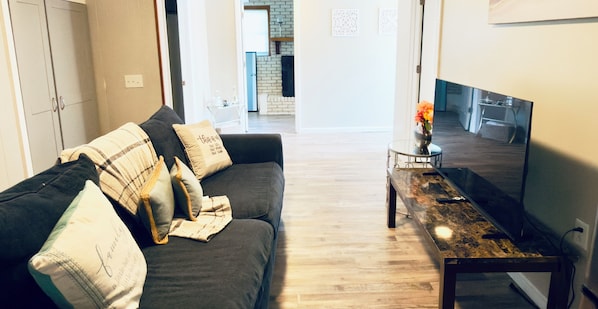 Un salon avec un canapé, une table basse et un téléviseur.