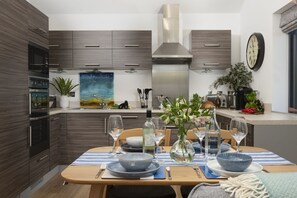 Enjoy cooking in this well-lit kitchen with a central island and stainless steel range hood.