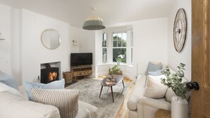 A cozy living room with a fireplace, a television, and comfortable seating.