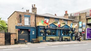 Un pub appelé « The Raven », doté d’une terrasse et arborant plusieurs drapeaux.