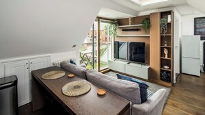 Une cuisine compacte avec un coin repas, un téléviseur encastré et un petit réfrigérateur.