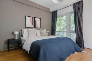 Relax in a serene bedroom with a comfortable bed, nightstand, and artwork.