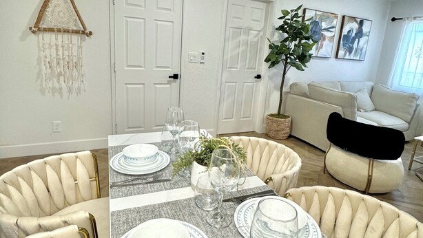 A dining area with a table set for four, surrounded by upholstered chairs. - 3 BR Cottage House Near Strip! (Las Vegas)