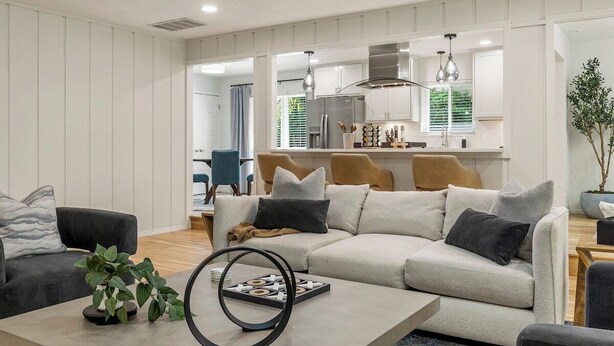 A modern living room with a sofa, coffee table, and a dining area in the background. - Tulsa Twilight Terrace@StFrancis (Tulsa)