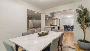 A modern dining area with a marble table, grey chairs, and a potted plant. - Tulsa Twilight Terrace@StFrancis (Tulsa)