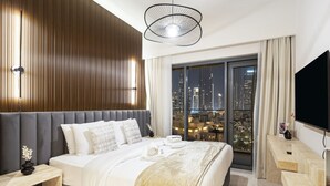 Ein modernes Hotelzimmer mit einem großen Bett, Blick auf die Stadt, einem Flachbildfernseher und einer Wand mit Holzvertäfelung.