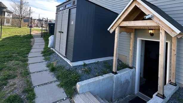 En boligbygning med en overdækket veranda, garage og sti til indgangen.