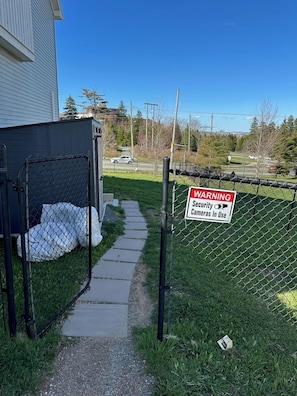 A fenced area with a warning sign for security cameras.