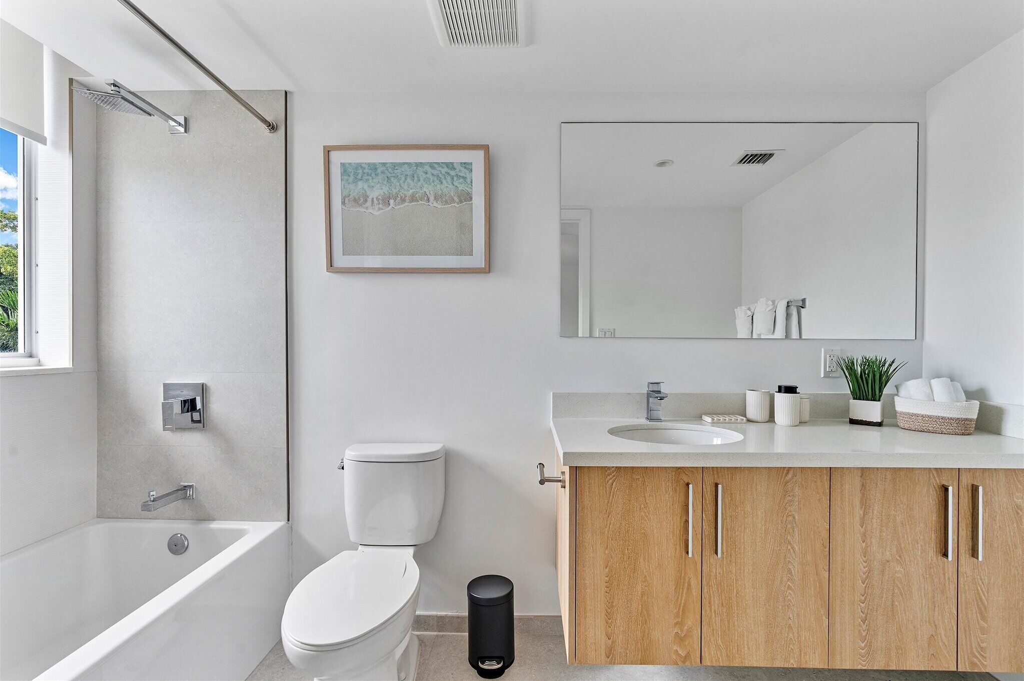 Une salle de bain moderne équipée d’une baignoire, de toilettes, d’un lavabo et d’un meuble en bois.