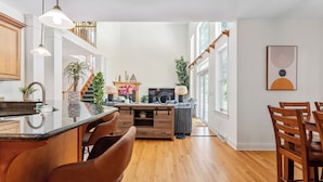 A spacious kitchen with a central island, wooden chairs, and a dining area with a table and chairs. - Hera Haven: Pickleball, hot tub, racetrack & lake (Stillwater)