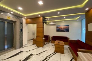 Un vestíbulo con mostrador de recepción, zona de estar y un ventanal grande.
