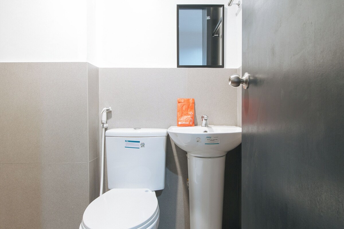Une salle de bain avec des toilettes, un lavabo et une porte.