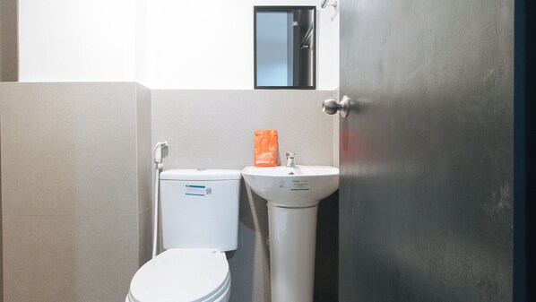 Une salle de bain avec des toilettes, un lavabo et une porte.