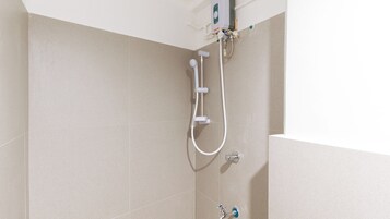 A shower with a handheld showerhead and a wall-mounted faucet.