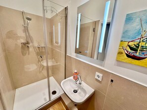 Chuveiro, secador de cabelo, toalhas de banho, sabonete