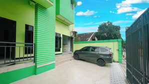 Un edificio verde con un coche estacionado adelante.