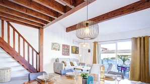 A dining area with a wooden table set for a meal, a staircase, and a view of the outside. - Villa 12 Cassin by Interhome (Canet-Plage)