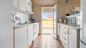 A compact kitchen with white cabinets, a coffee maker, and a microwave. - Pet friendly home in Thisted with sauna (Thisted)