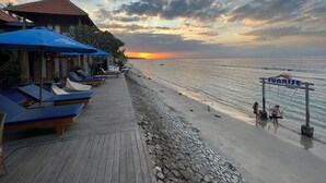 En træterrasse med liggestole og et skilt med teksten Sunrise Cottage.