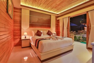 Habitación de hotel con una cama grande, una mesita de noche, televisor montado en la pared y vista al exterior.