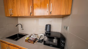 A kitchenette with a microwave, coffee maker, and a kettle. - Sunrise Cottage Penida (Penida Island)